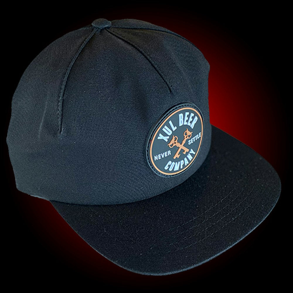 One panel black hat with a round rubber patch with our circle logo.